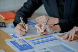 Two people looking over a spreadsheet of an organization's processes.